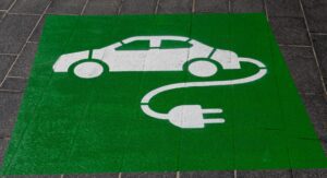 Hoe duurzaam is een elektrische auto. Groene wegmarkering auto aan stekker.