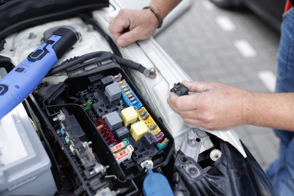automonteur bezig met auto-elektronica voor het onderhoud van een elektrische auto